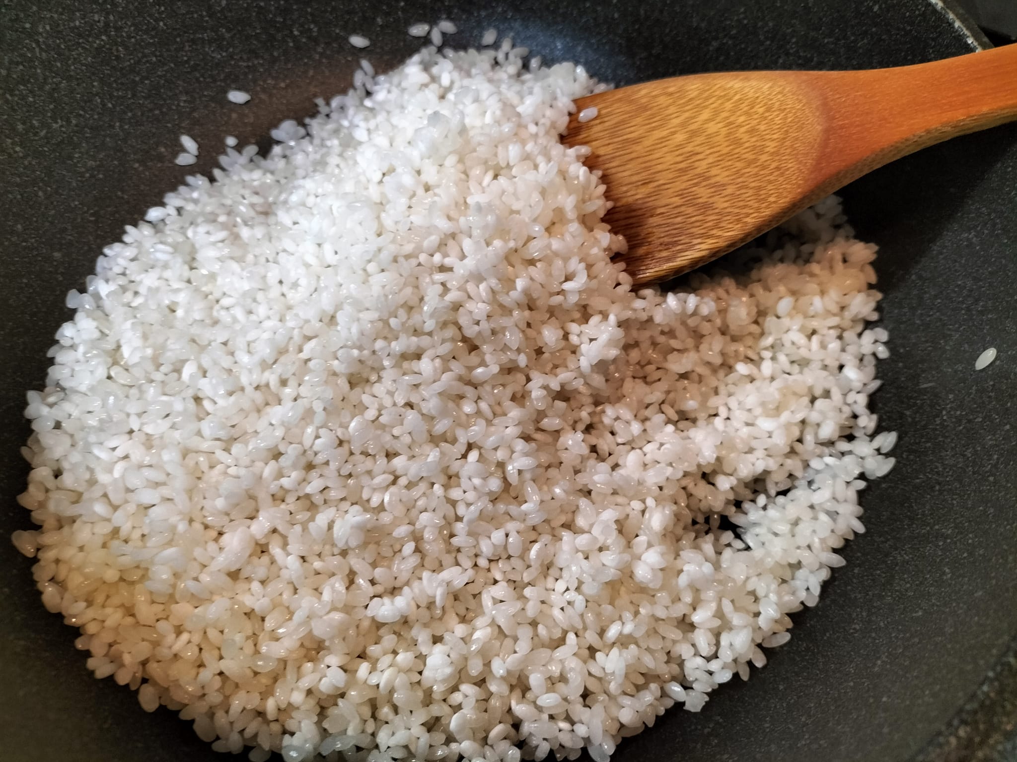 お米をフライパンで炒めている写真