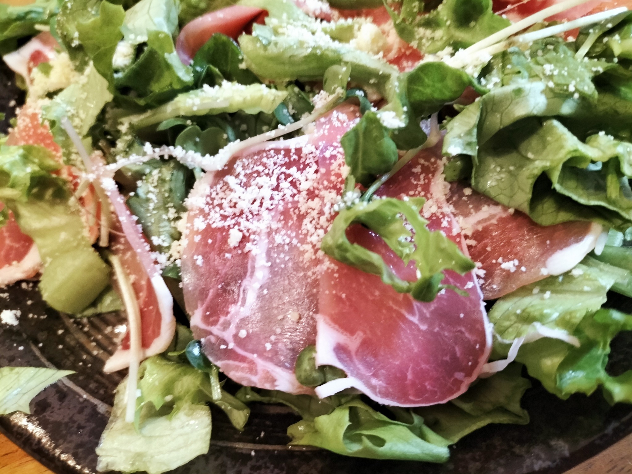 粉チーズを振りかけた生ハムサラダ