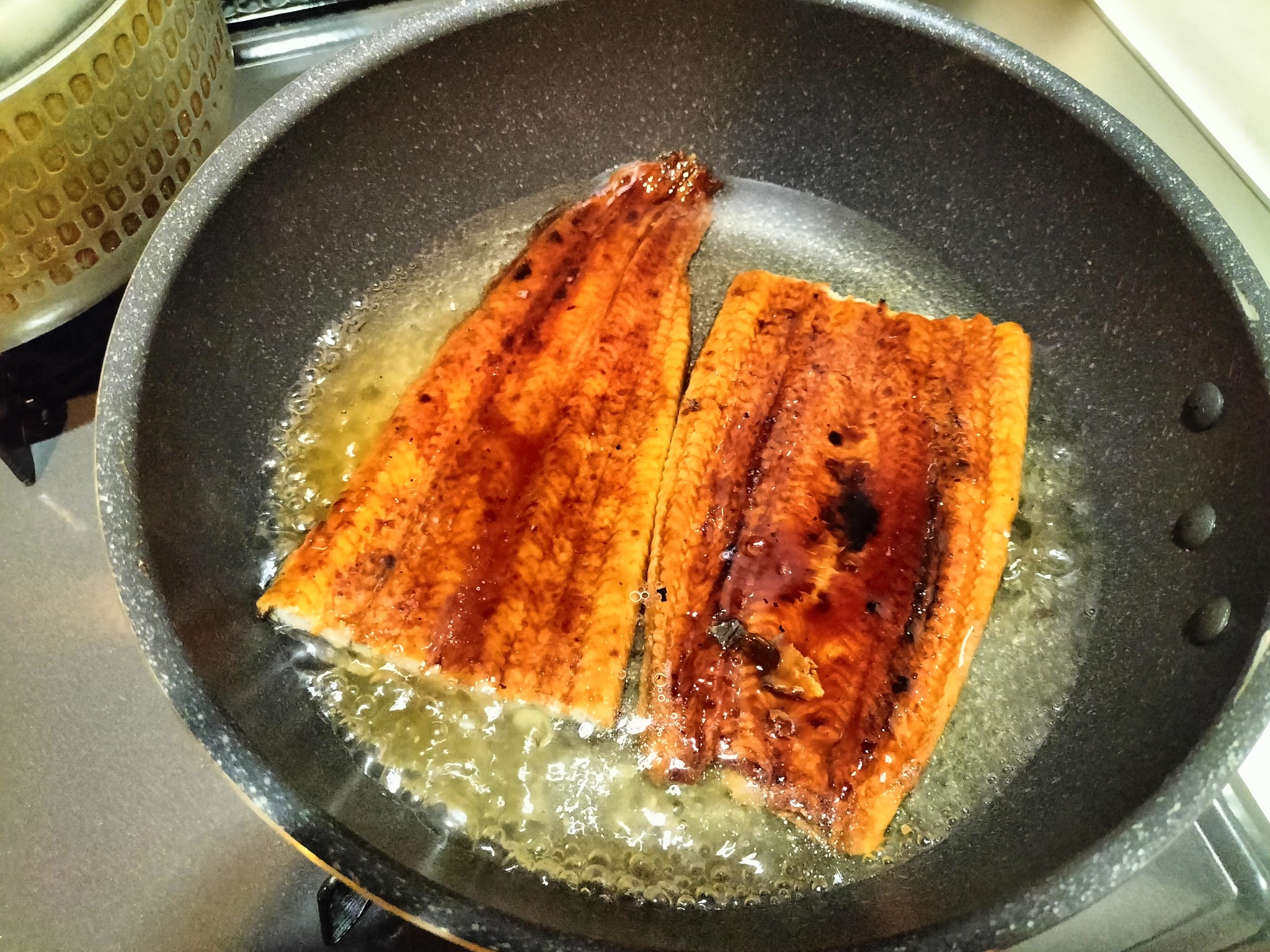 フライパンで茹でているうなぎ