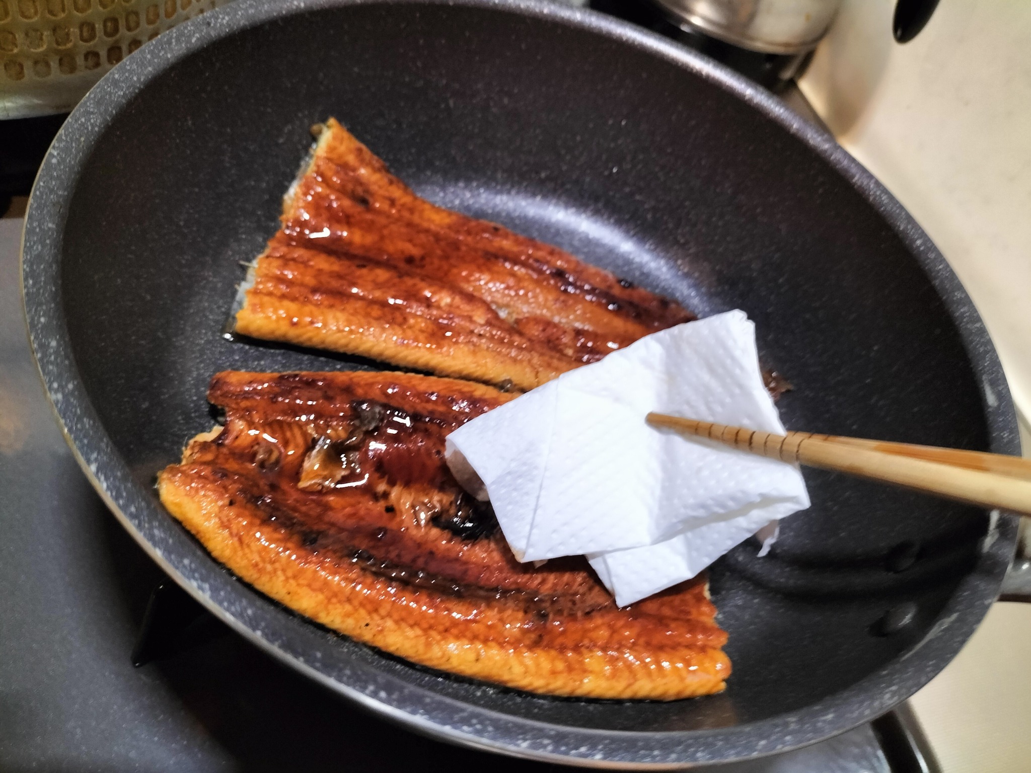 キッチンペーパーでフライパンの水気をふいている