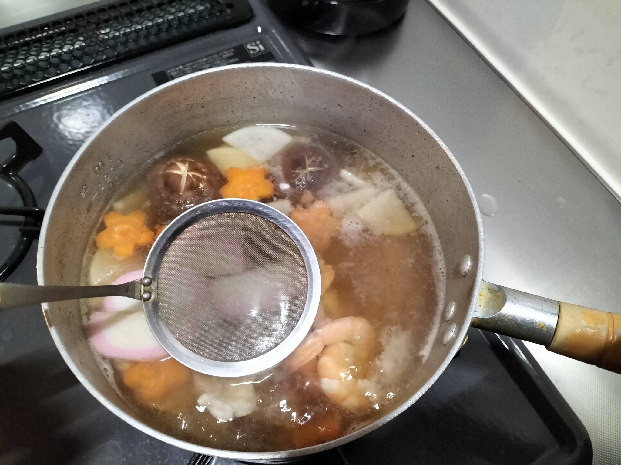 アクを取りながら煮ている