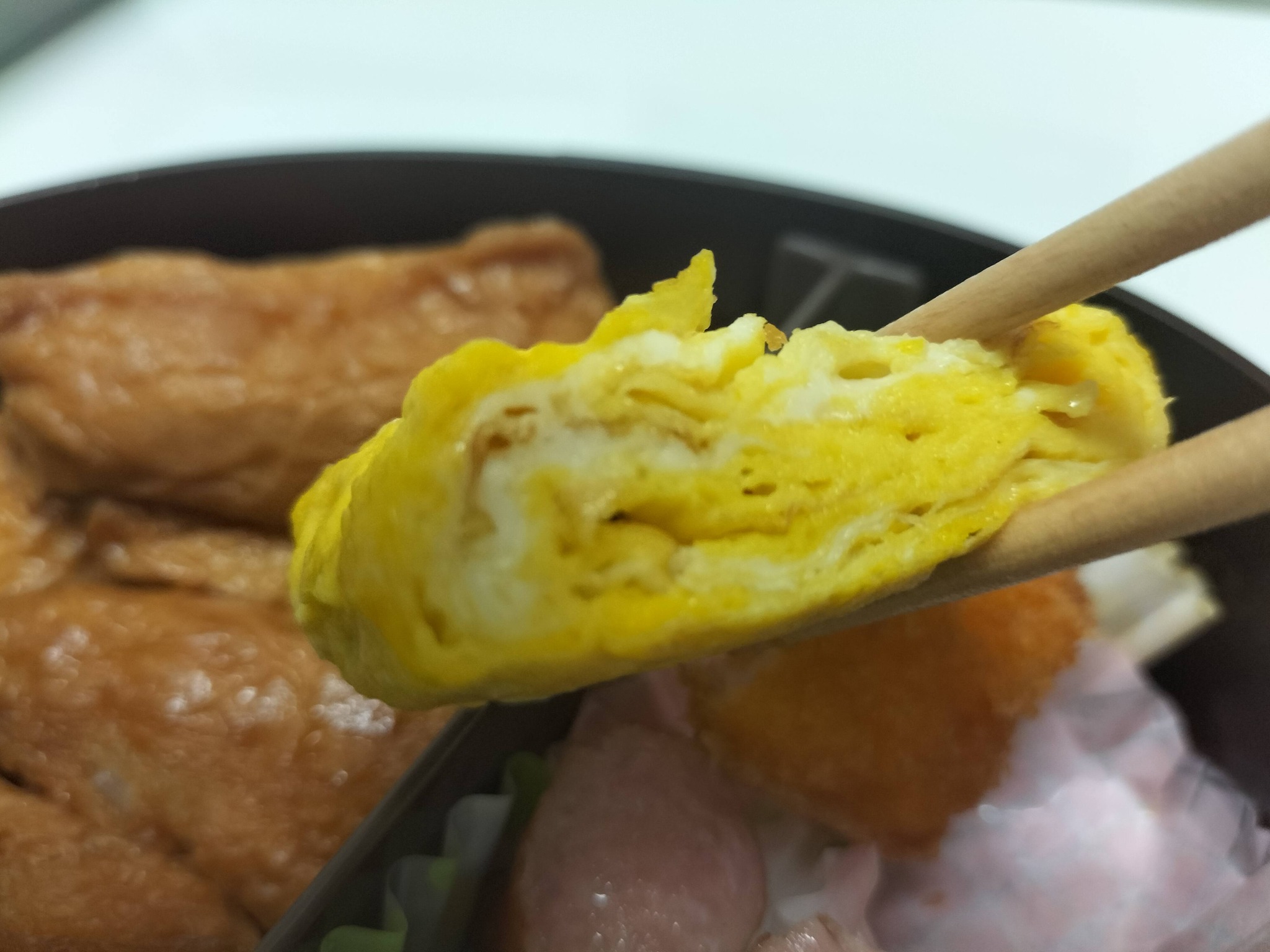 今日のお弁当のおかずの卵焼きを食べている