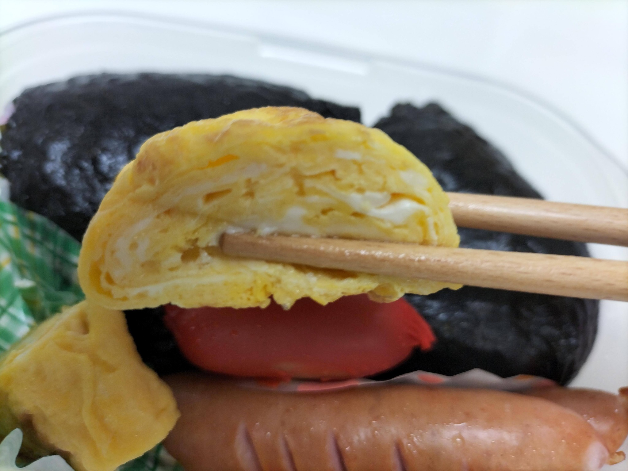 弁当の卵焼きを食べている