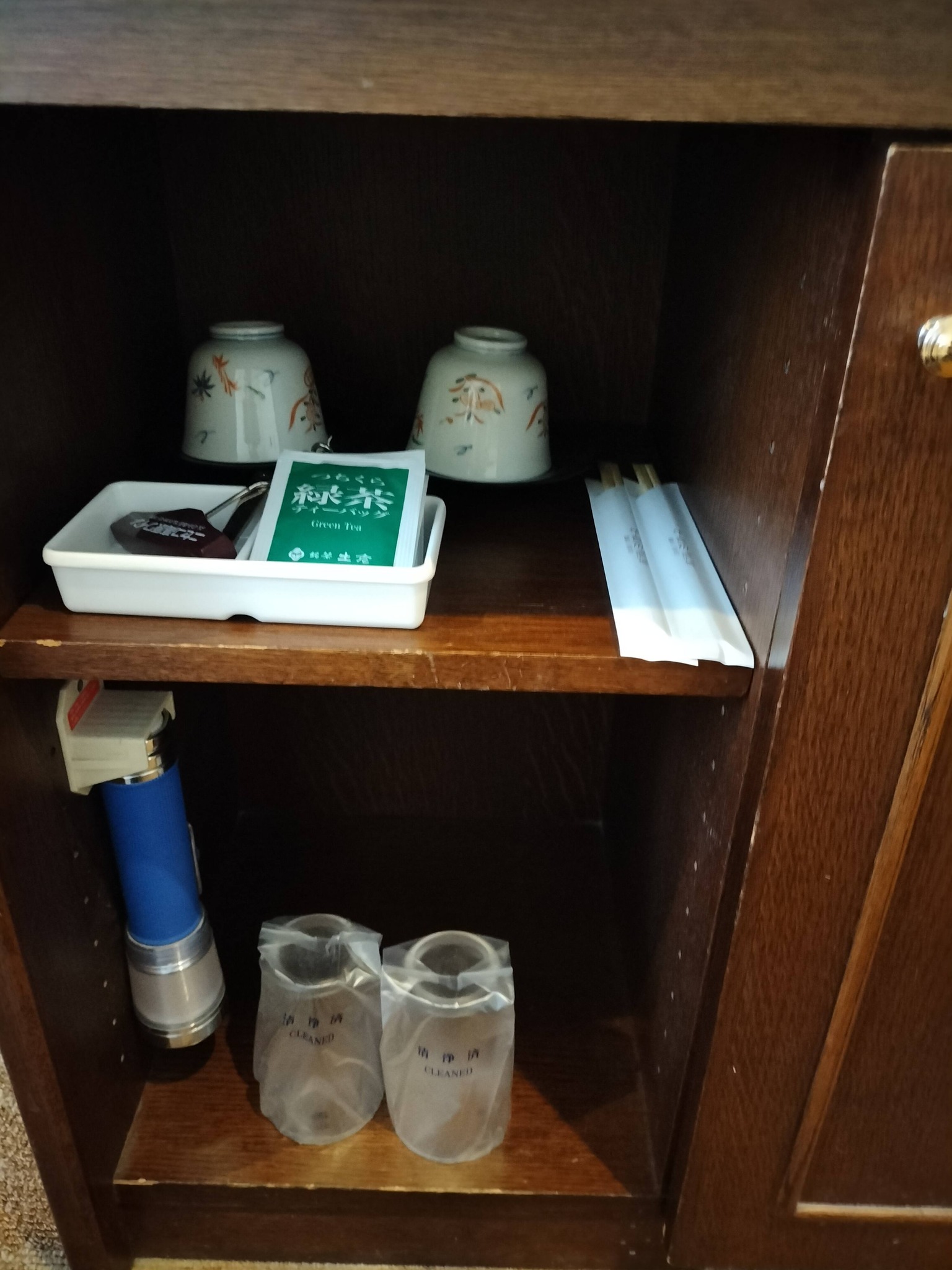 キャビネットの、冷蔵庫とアイスペール、ティパック、湯のみ。割りばし