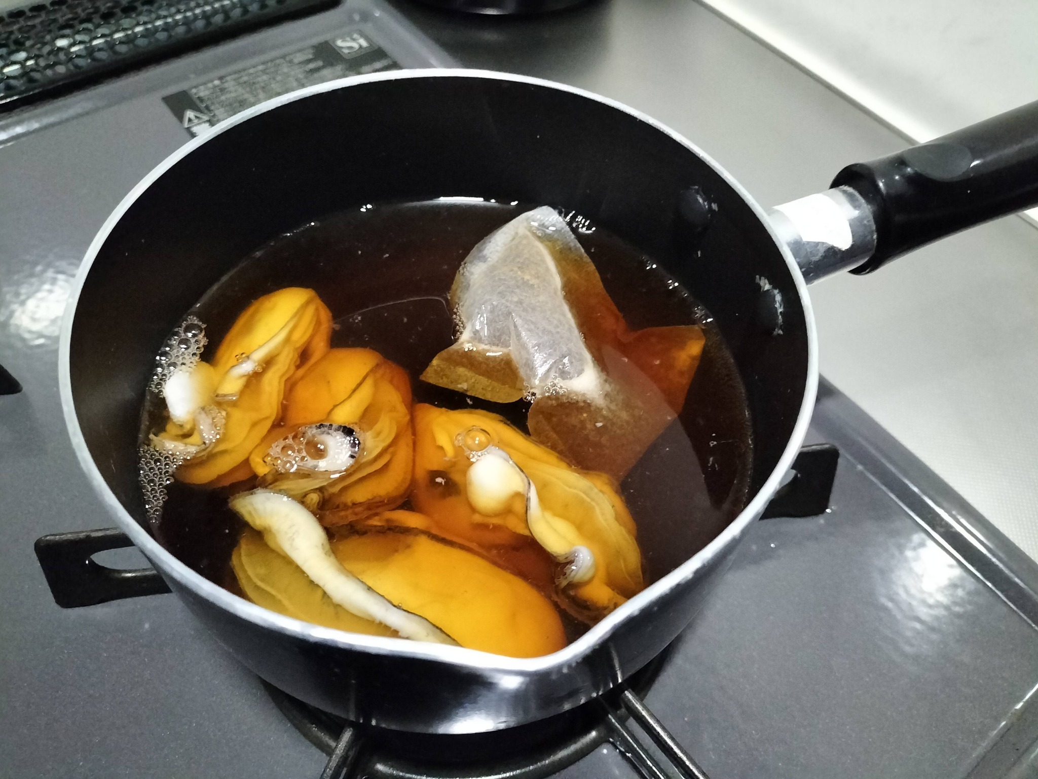 合わせた調味料で牡蠣を下茹でしている